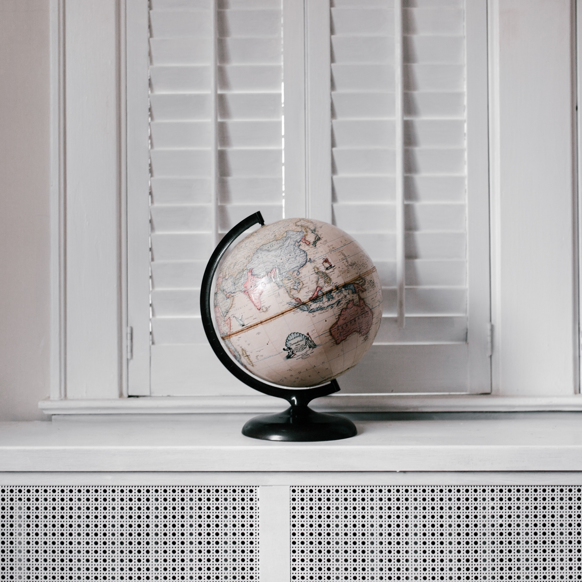 A pale coloured globe of the world against a white background