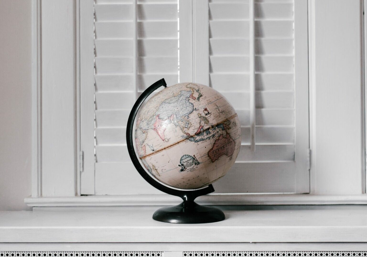 A pale coloured globe of the world against a white background