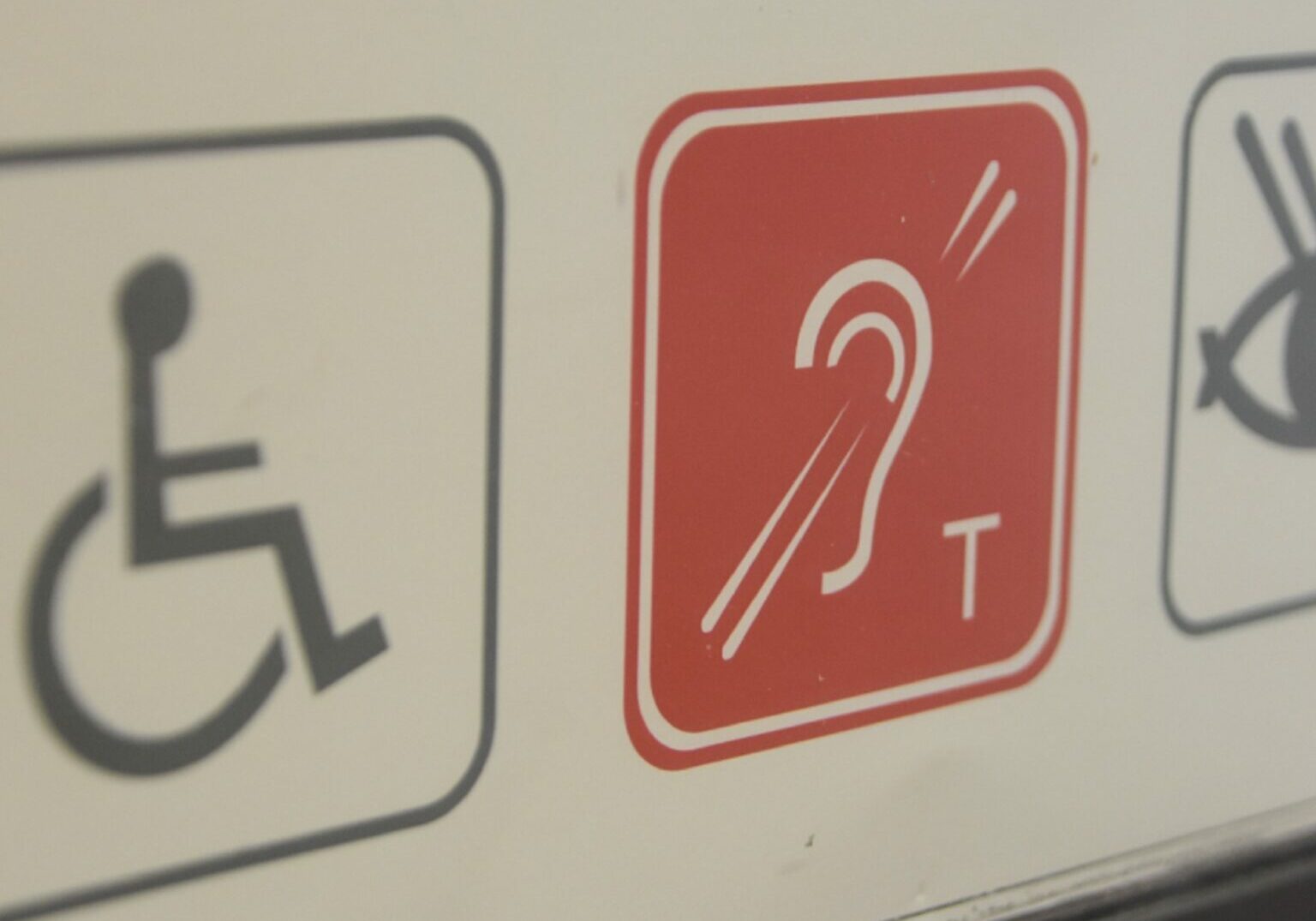 An image of symbols relating to disability including for a wheelchair and a hearing loop